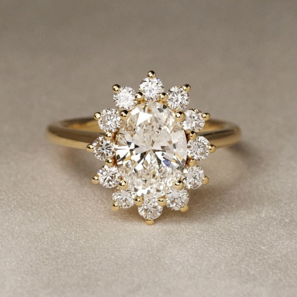 A yellow gold ring featuring a large oval center diamond surrounded by a halo of smaller round diamonds, set against a neutral textured beige background.