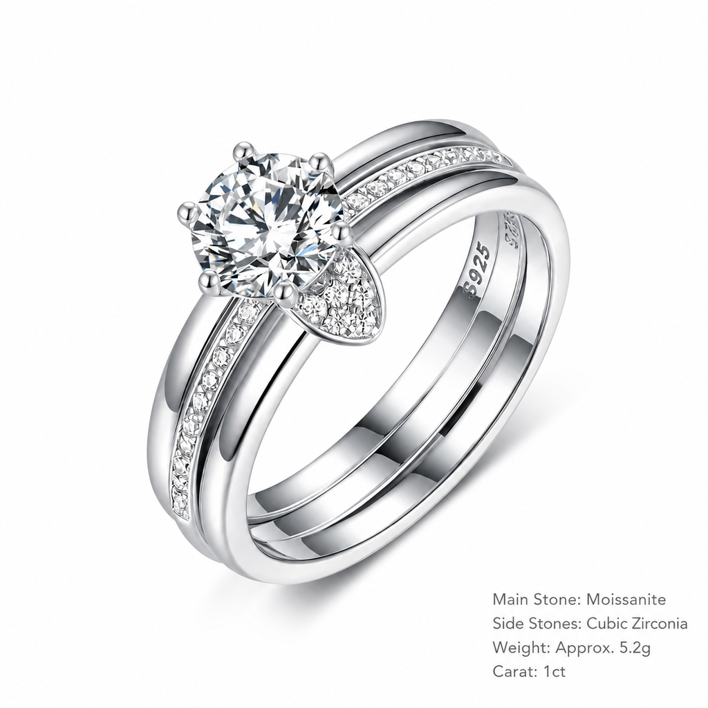 A silver-toned double-band ring set featuring a round-cut Moissanite center stone and small cubic zirconia side stones, shown on a clean white background with product details printed in the lower right corner.