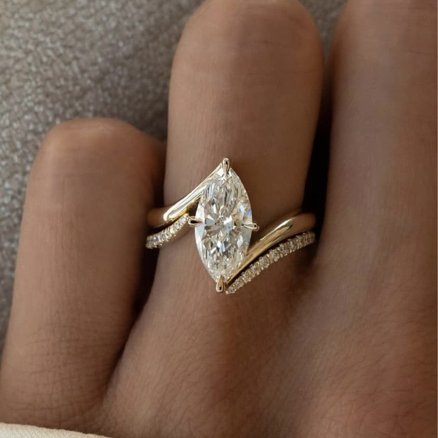 Gold ring with a pear-shaped diamond on a finger