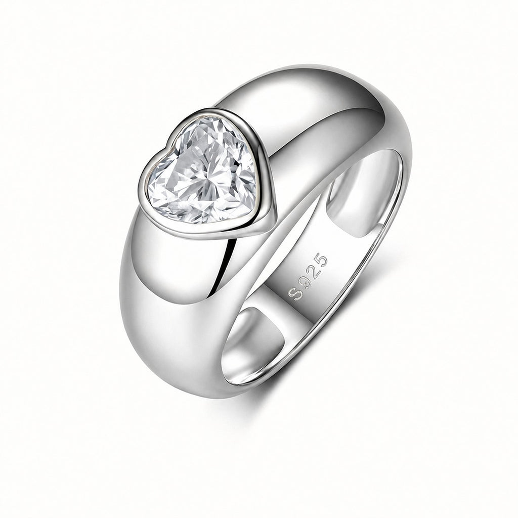 A polished sterling silver ring featuring a heart-shaped clear gemstone in a bezel setting, with 'S925' stamped on the inner band, shown on a clean white background.