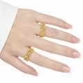 A person's hand wearing two 925 sterling silver rings with a rhombus bead design, one in an 18K yellow gold finish and the other in a rhodium finish.
