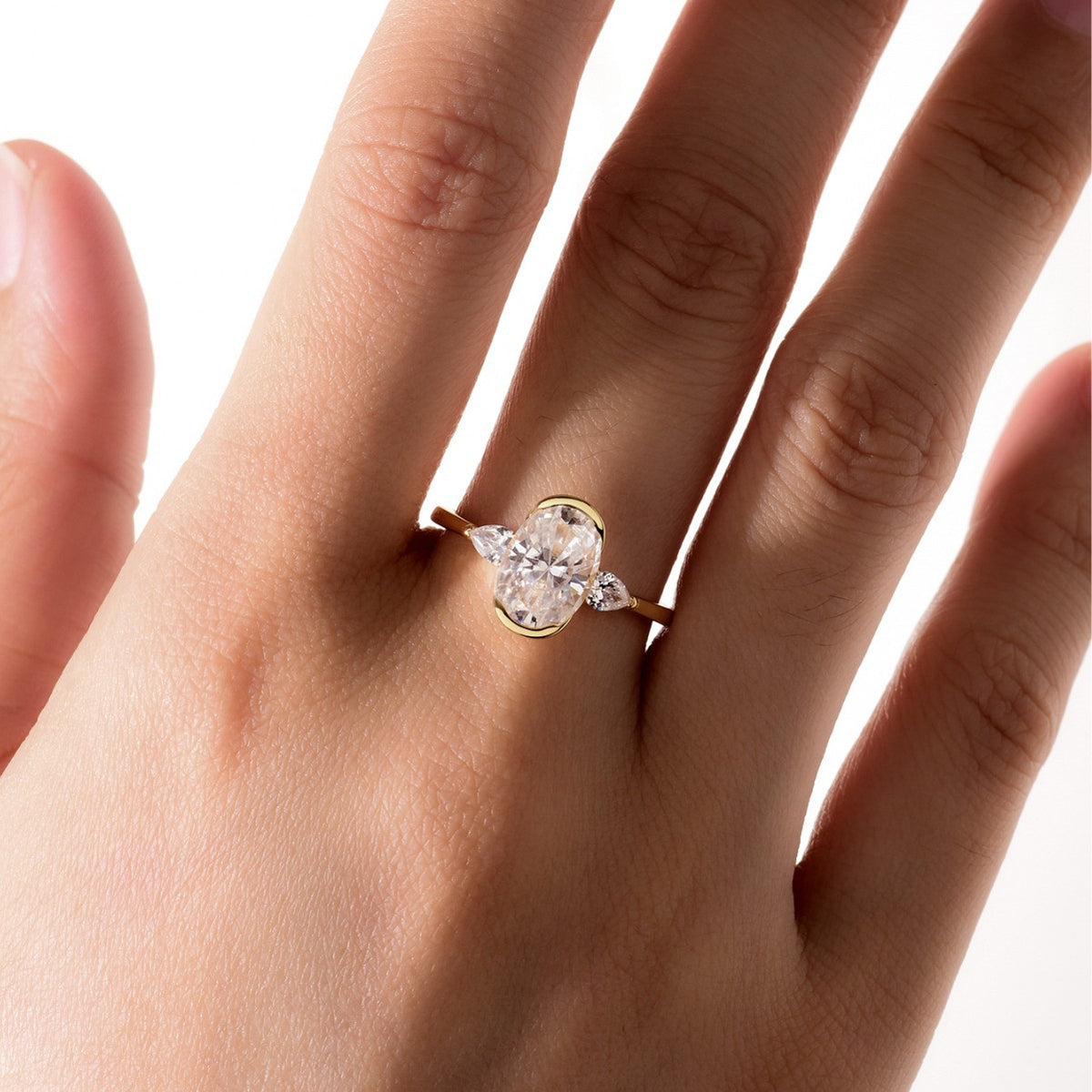 Hand wearing a diamond ring on a white background