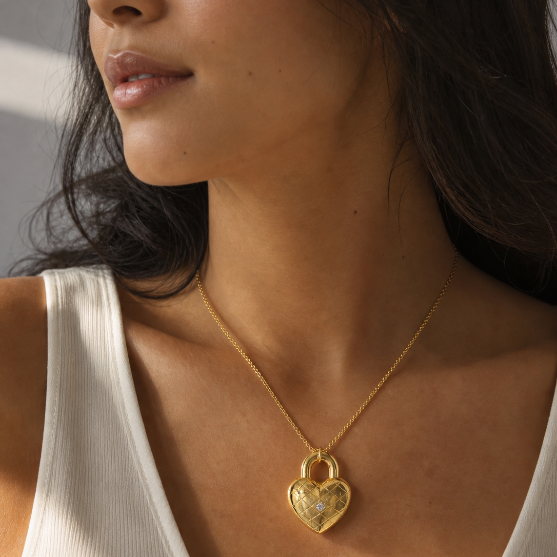 Close-up of a woman wearing a gold heart-shaped necklace.