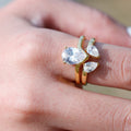Gold ring with pear-shaped gemstones on a finger