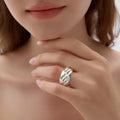 Close-up of a hand wearing a silver ring with a blurred background