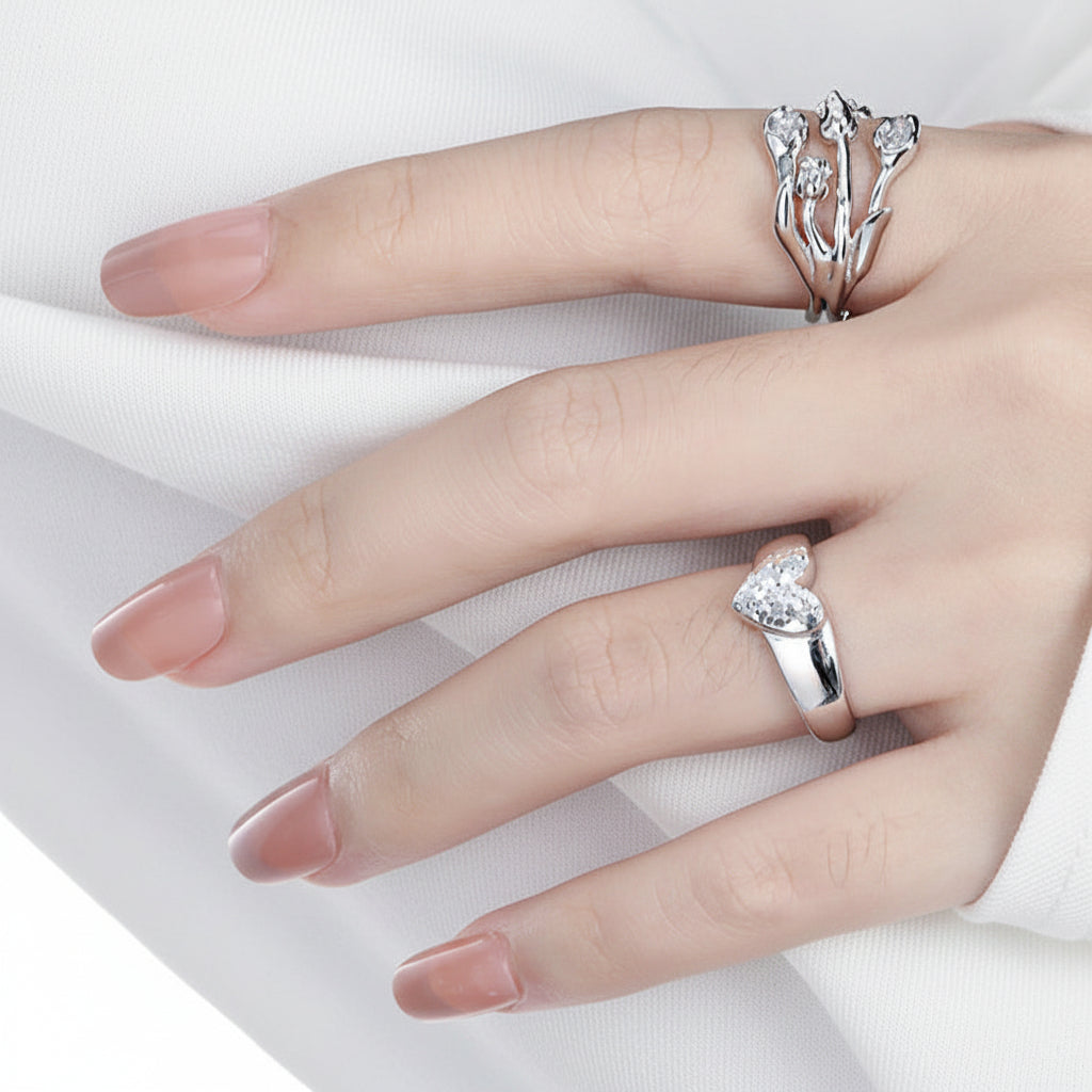Hand wearing two silver rings on a dark background