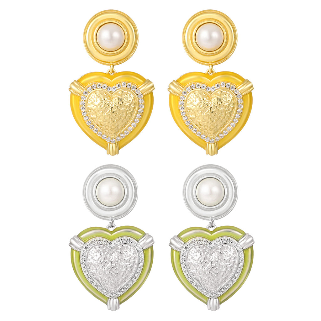 Pair of heart-shaped earrings in gold, silver, and green on a white background