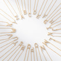 Gold necklaces with letters spelling out a name on a white background