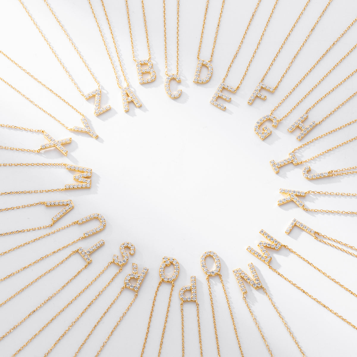 Gold necklaces with letters spelling out a name on a white background