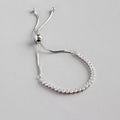 Silver bracelet with small diamonds on a light gray background