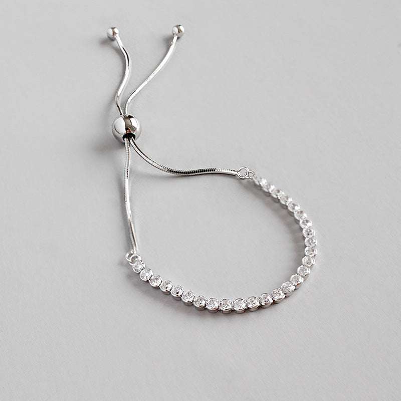 Silver bracelet with small diamonds on a light gray background