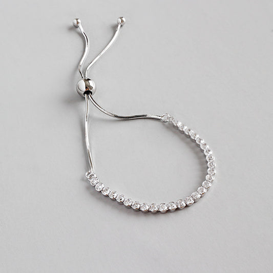 Silver bracelet with small diamonds on a light gray background